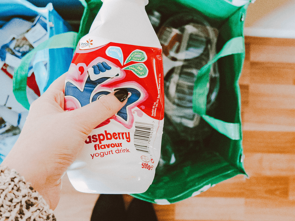 A female is recycling a plastic milk container
