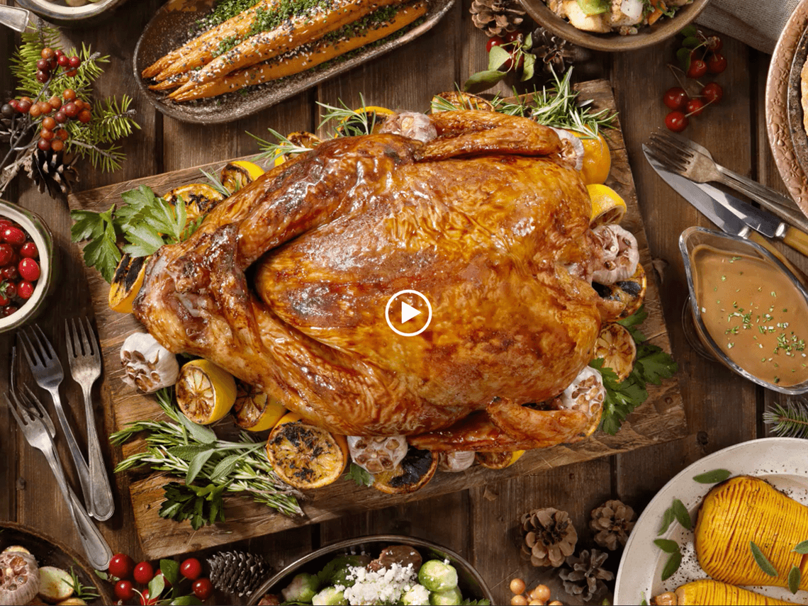 A table with Thanksgiving turkey, stuffing, carrots, and mashed potatoes