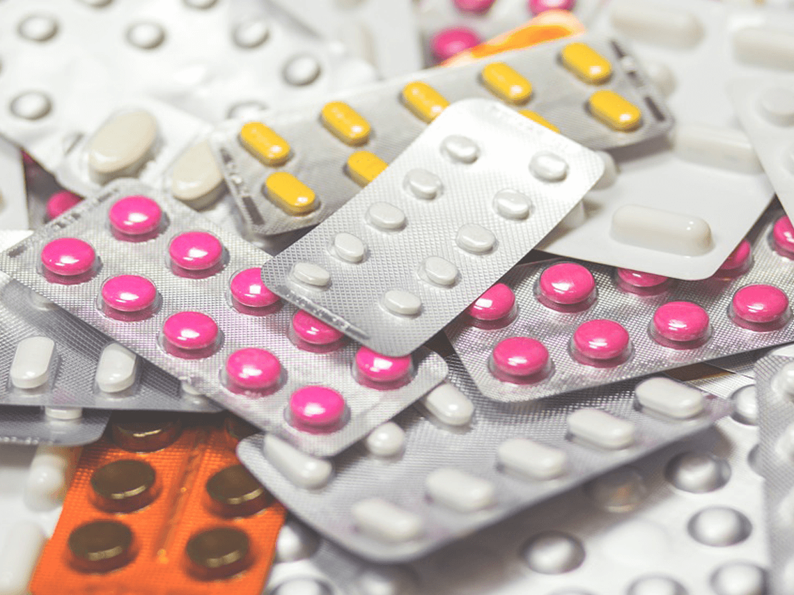 Pile of pill packages containing different colors of tablets