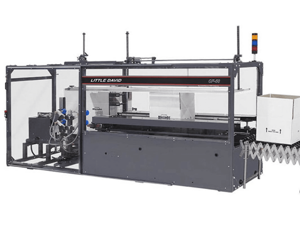 A large packaging machine with 2 white boxes moving along the belt