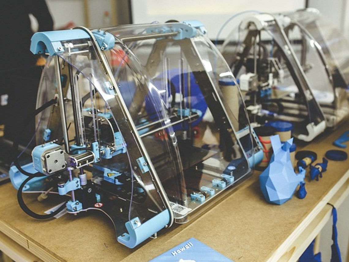 A small 3D printing machine sitting on top of a small table