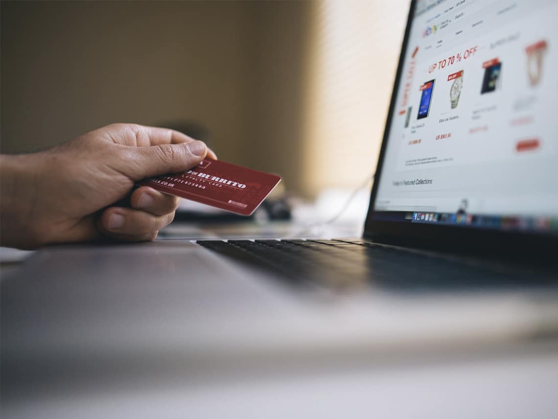 A person holding a credit card is about to make a purchase on an online website