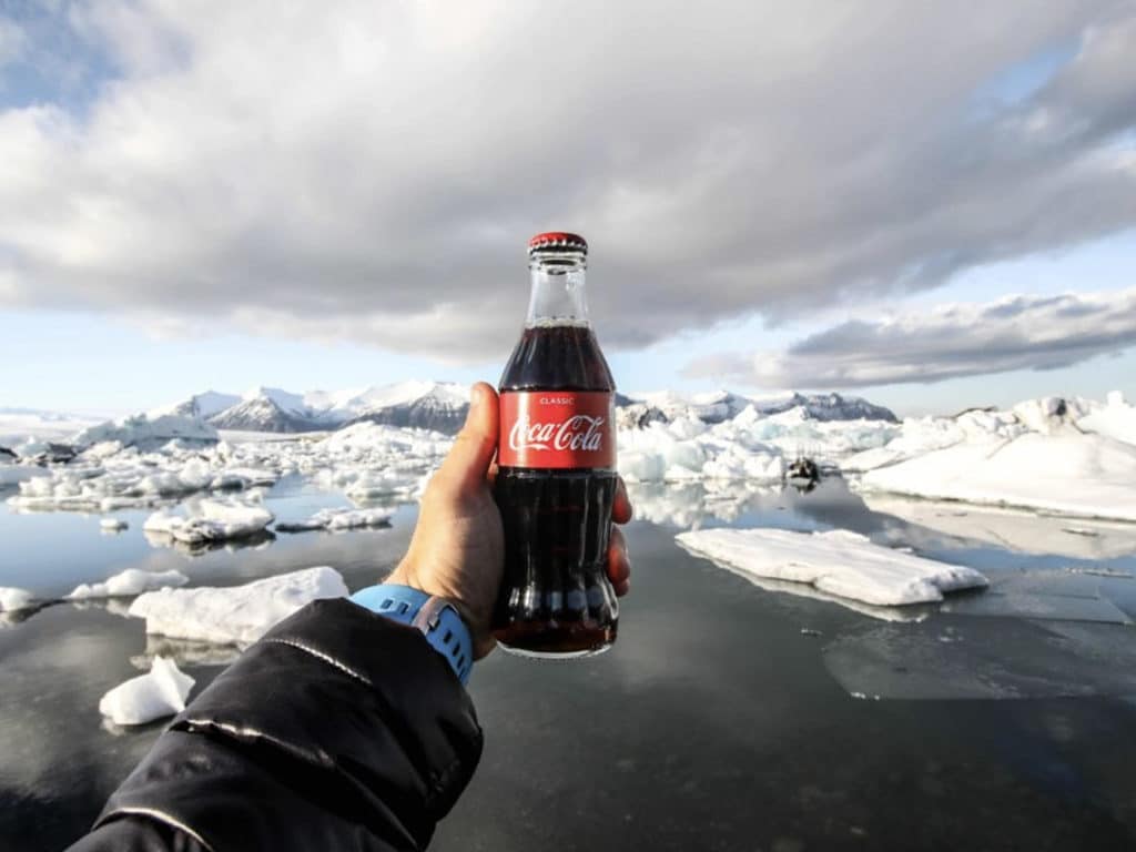 A shot of someone holding a Coca-Cola bottle with an icy background