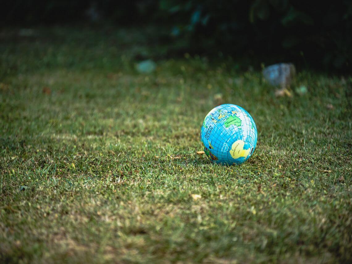 A ball that is meant to look like Earth sits on the grass
