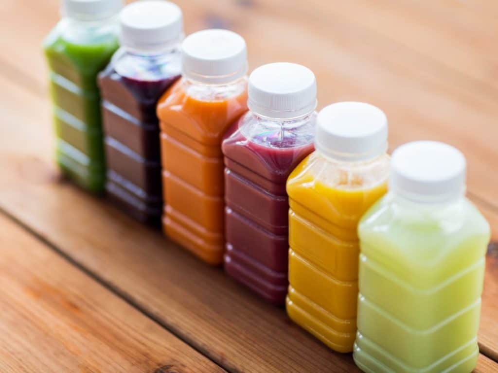 A row of different colored beverage packaging for juice