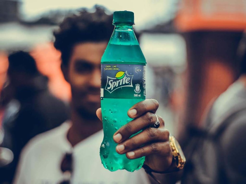 A young man holds up a Sprite bottle showcasing thermoformed plastics