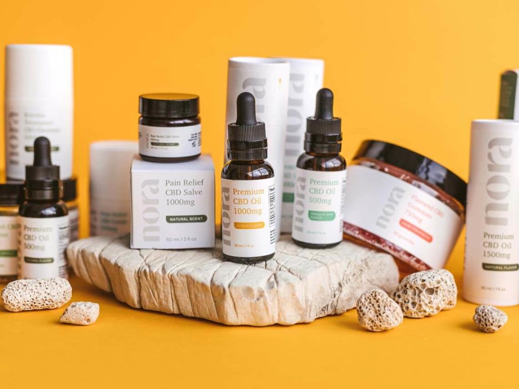 A display of CBD products with a yellow backdrop