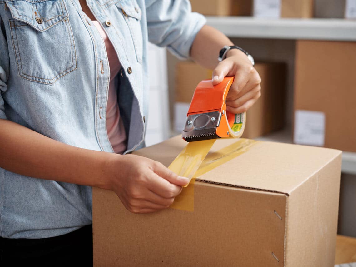 Women taping corrugated packaging box