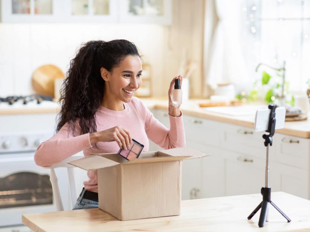 Woman creating an unboxing video for cosmetics